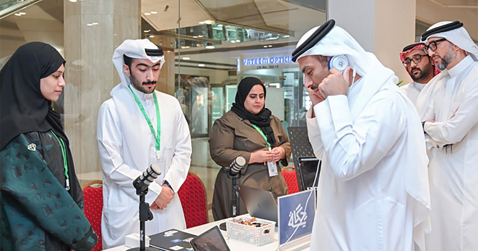 A group of individuals are crowded around a desk at the digital conference